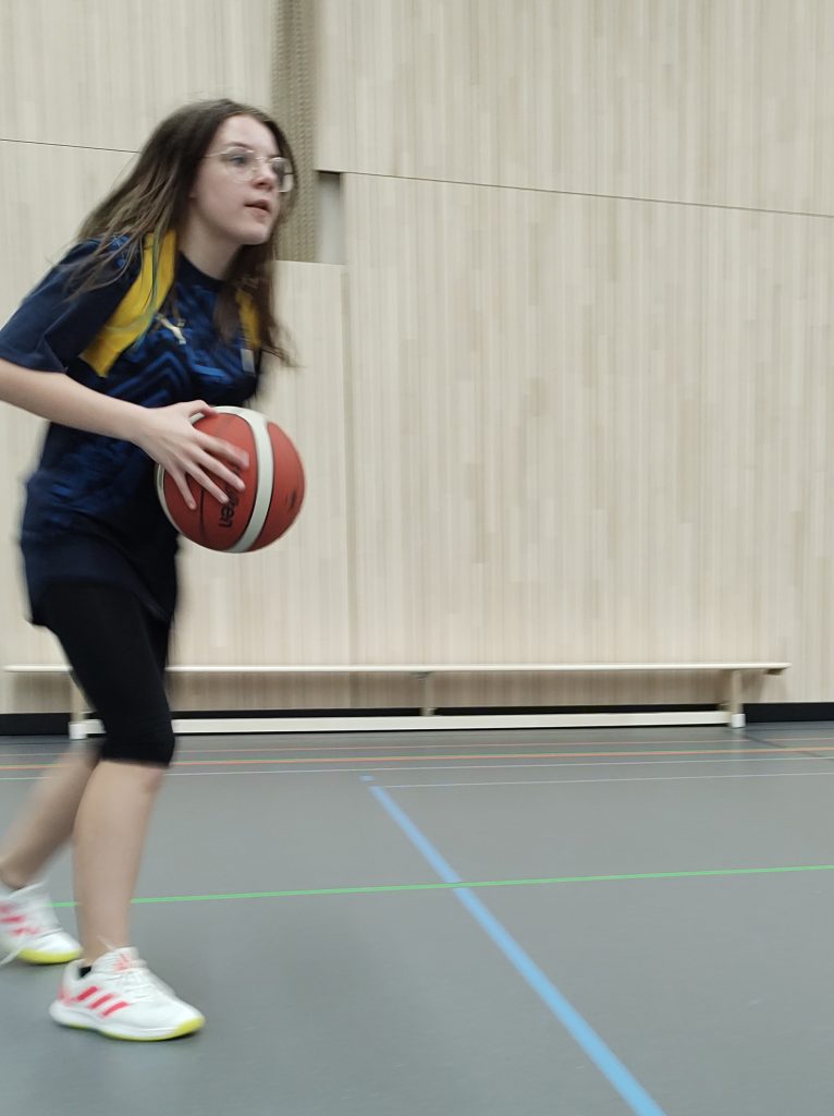 Ein Mädchen mit Basketball sucht ihre Mitspielerin für den Pass