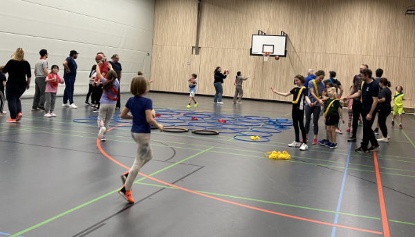 Kinder und ihre Familien spielen ein Wurfspiel beim gemeinsamen Weihnachtstraining