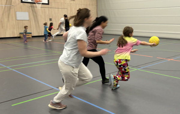 Zwei Mütter packt der Ehrgeiz während ein Kind ihnen den Basketball wegschnappt